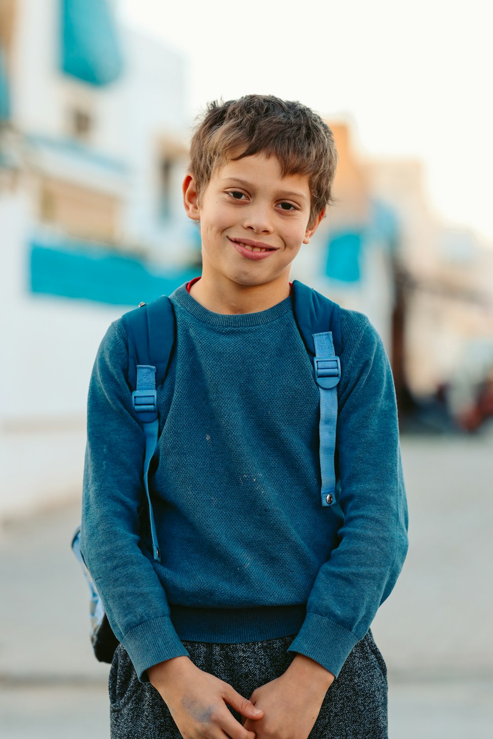 Boy with a backpack on the sidewalk