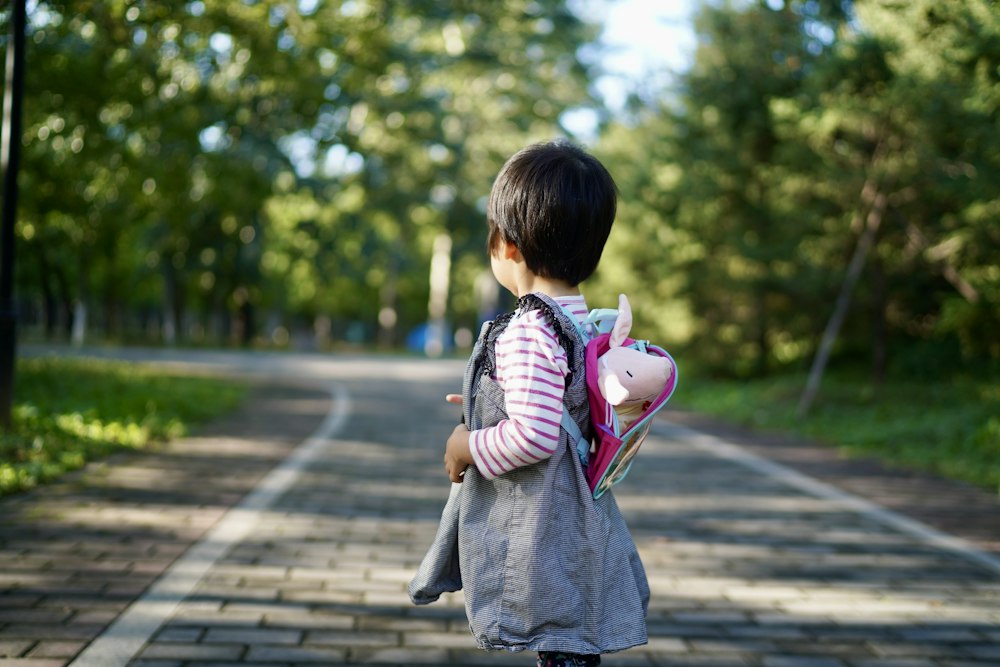 Child with backpack walking on a path