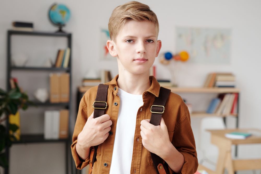 Boy carrying a brown backpack